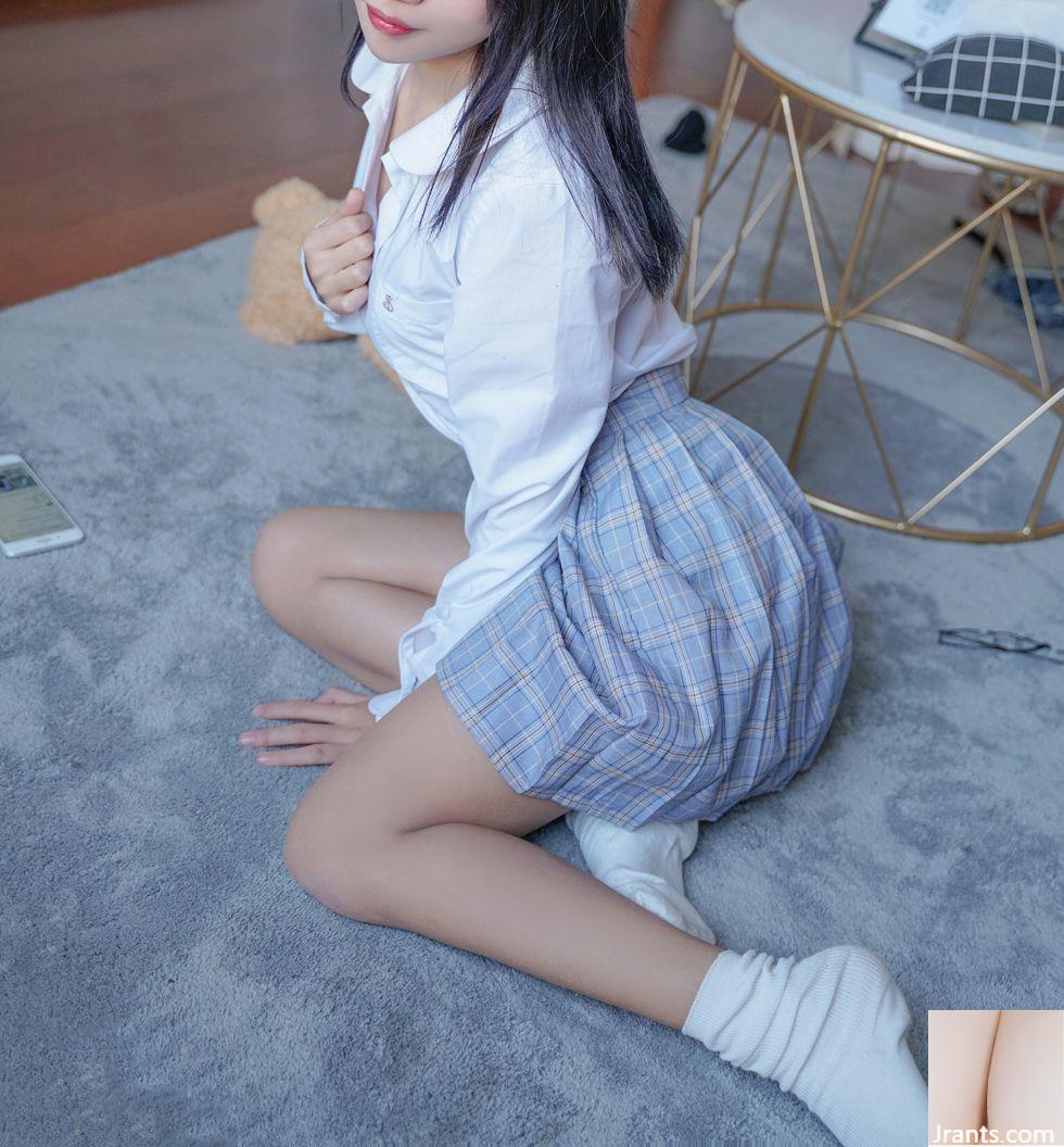 Foto sexy de una hermosa mujer con una camisa blanca mostrando sus hermosas piernas con una falda a cuadros azul y calcetines blancos en su habitación privada (43P)